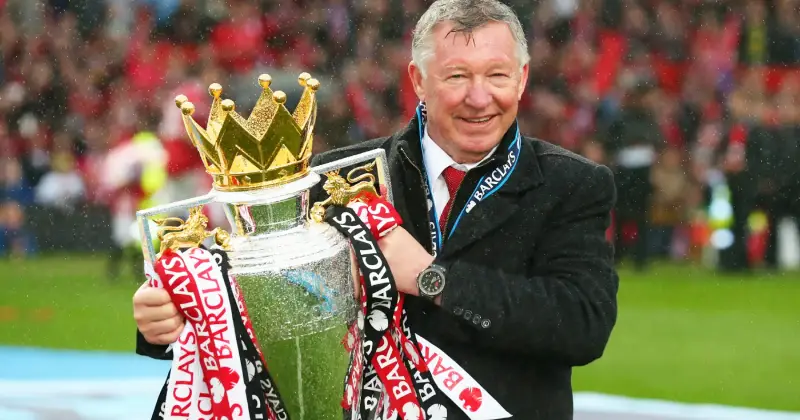 Sir Alex Ferguson tự hào cầm trên tay chiếc cúp vô địch Premier League, khuôn mặt rạng rỡ nụ cười đắc thắng.