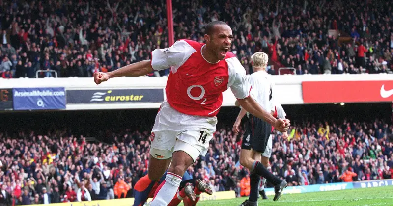 Thierry Henry, trong chiếc áo đấu mang tính biểu tượng của Arsenal, chạy nước rút với cánh tay dang rộng và nụ cười rạng rỡ, ăn mừng bàn thắng.